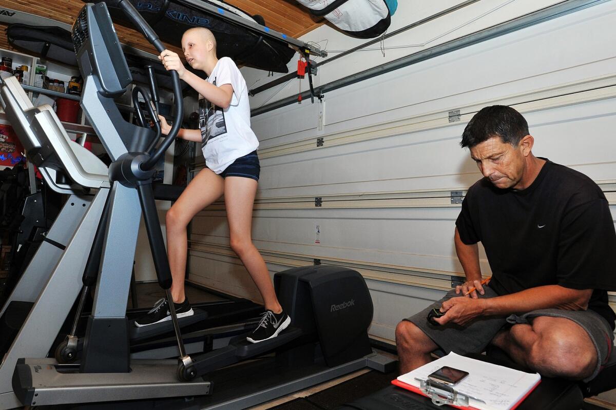 With her father Rodney keeping track of time, Kasey Harvey goes through her early morning workout before going to her morning chemo treatments. — Rick Nocon
