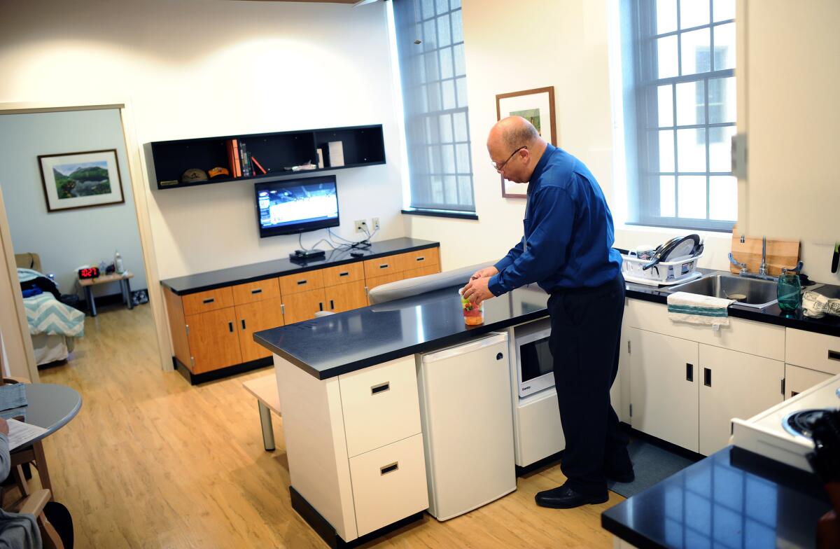 Veteran Keith Hudson opens a jar of fruit inside his home in the newly refurbished supportive housing at the Los Angeles VA campus.