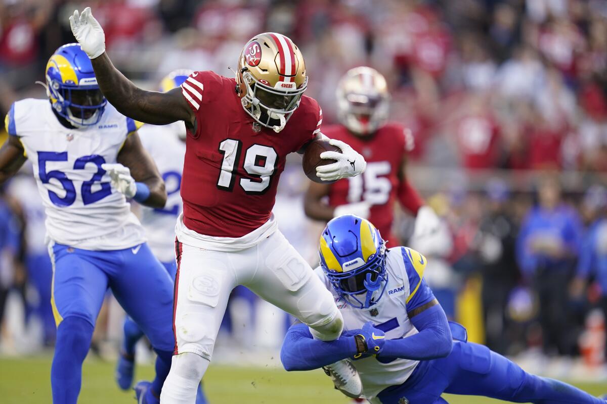San Francisco 49ers wide receiver Deebo Samuel breaks a tackle attempt by Rams cornerback Jalen Ramsey.