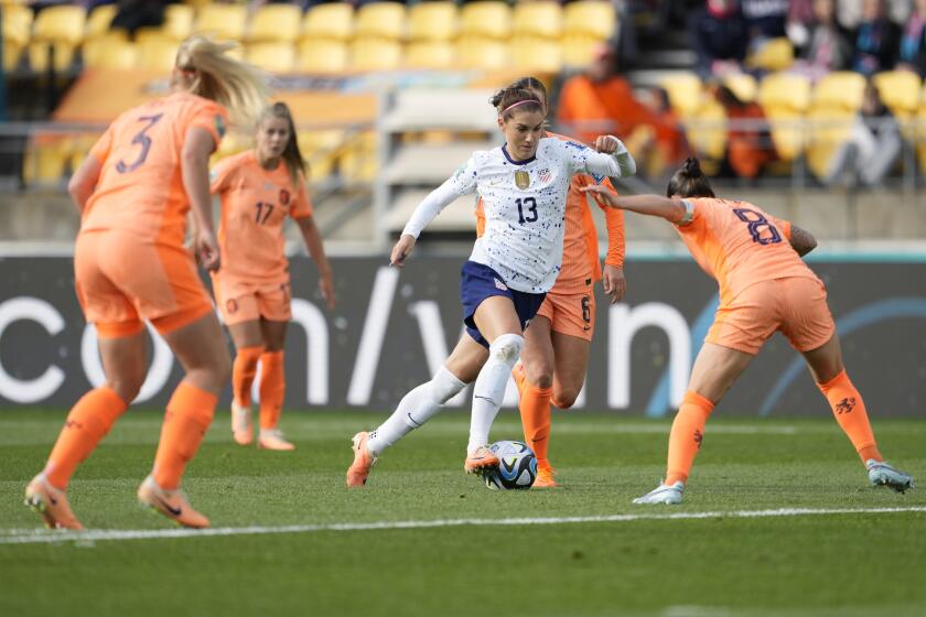Alex Morgan controls the ball in front of a crowd of Netherlands players
