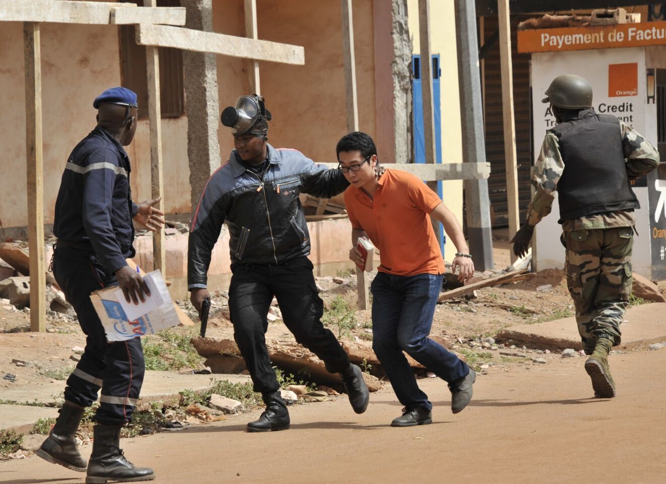 Malian security forces evacuate a man from an area surrounding the Radisson Blu hotel in Bamako.