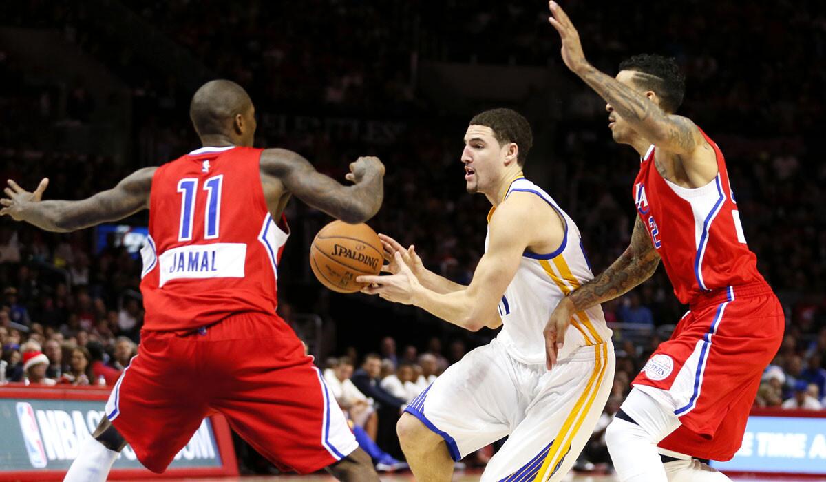 Clippers guard Jamal Crawford (11) and forward Matt Barnes force Warriors guard Klay Thompson to pass the ball as he drives toward the lane on Thursday night.