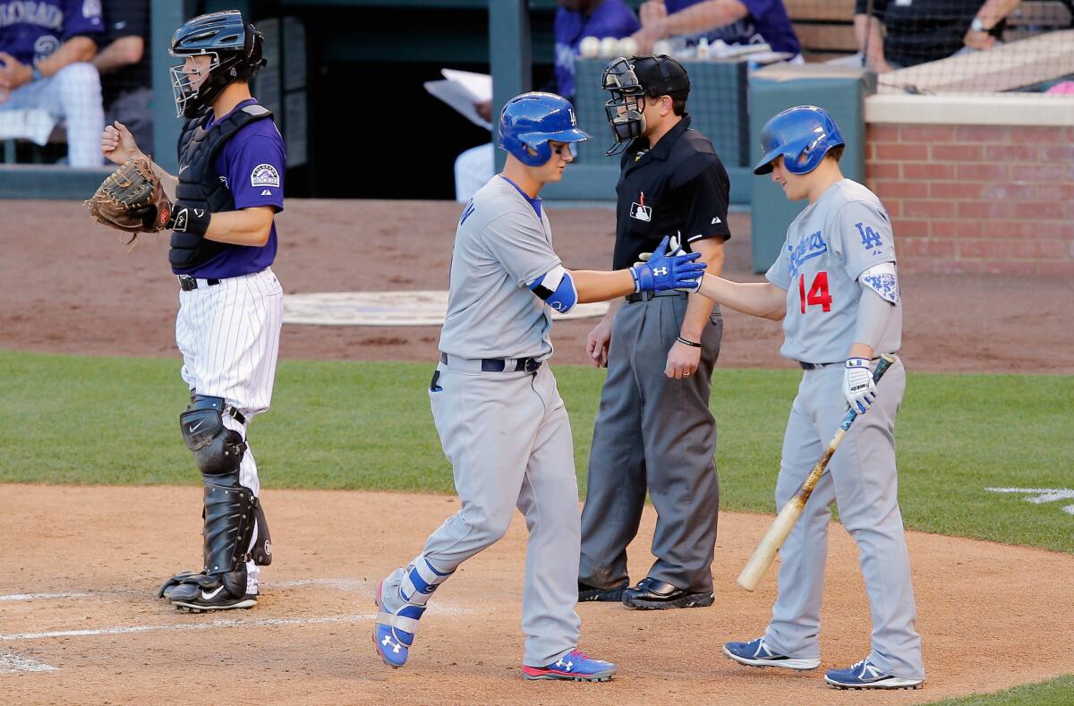 Dodgers outfielder Joc Pederson celebrates his long solo home run with Enrique Hernandez (14) in the second game of a doubleheader against the Rockies.