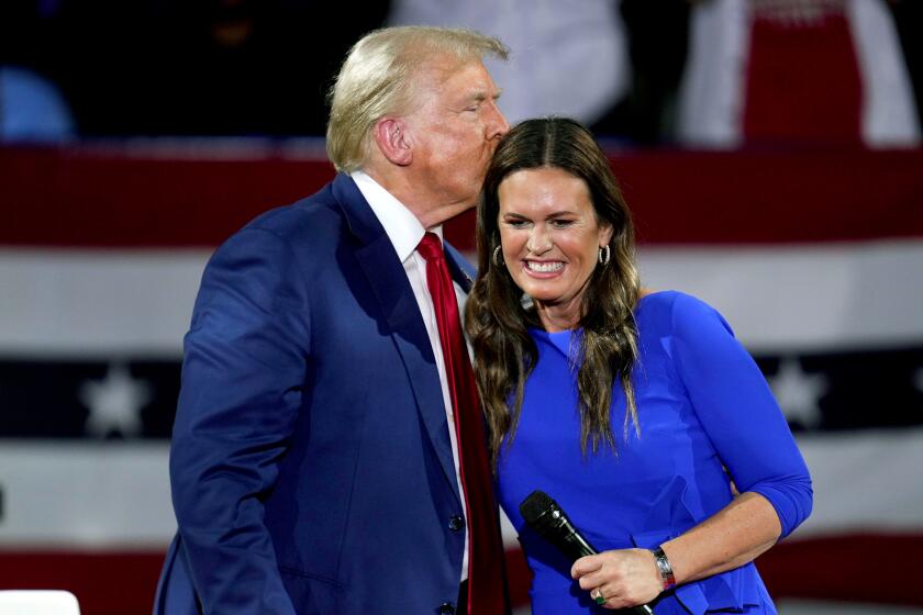 Republican presidential candidate former President Donald Trump, left, on stage with Arkansas Gov. Sarah Huckabee Sanders