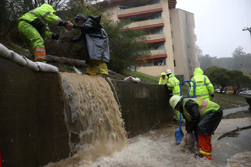 MARIN CITY, CALIFORNIA - OCTOBER 24: Workers try to divert water into drains as rain pours down on October 24, 2021 in Marin City, California. A Category 5 atmospheric river is bringing heavy precipitation, high winds and power outages to the San Francisco Bay Area. The storm is expected to bring anywhere between 2 to 5 inches of rain to many parts of the area. (Photo by Justin Sullivan/Getty Images)