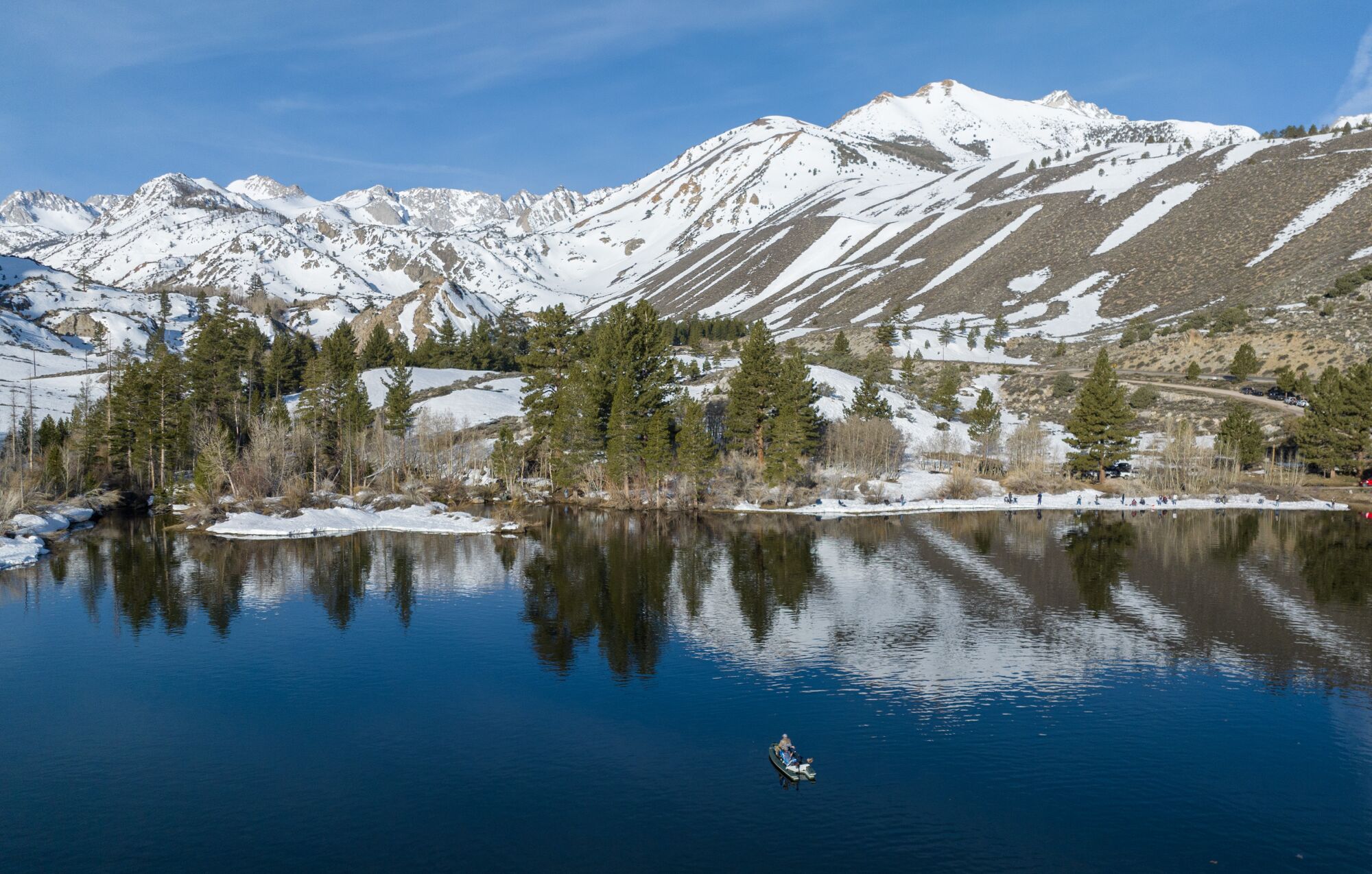 Snowy Sierra Nevada mountains reflected in water.
