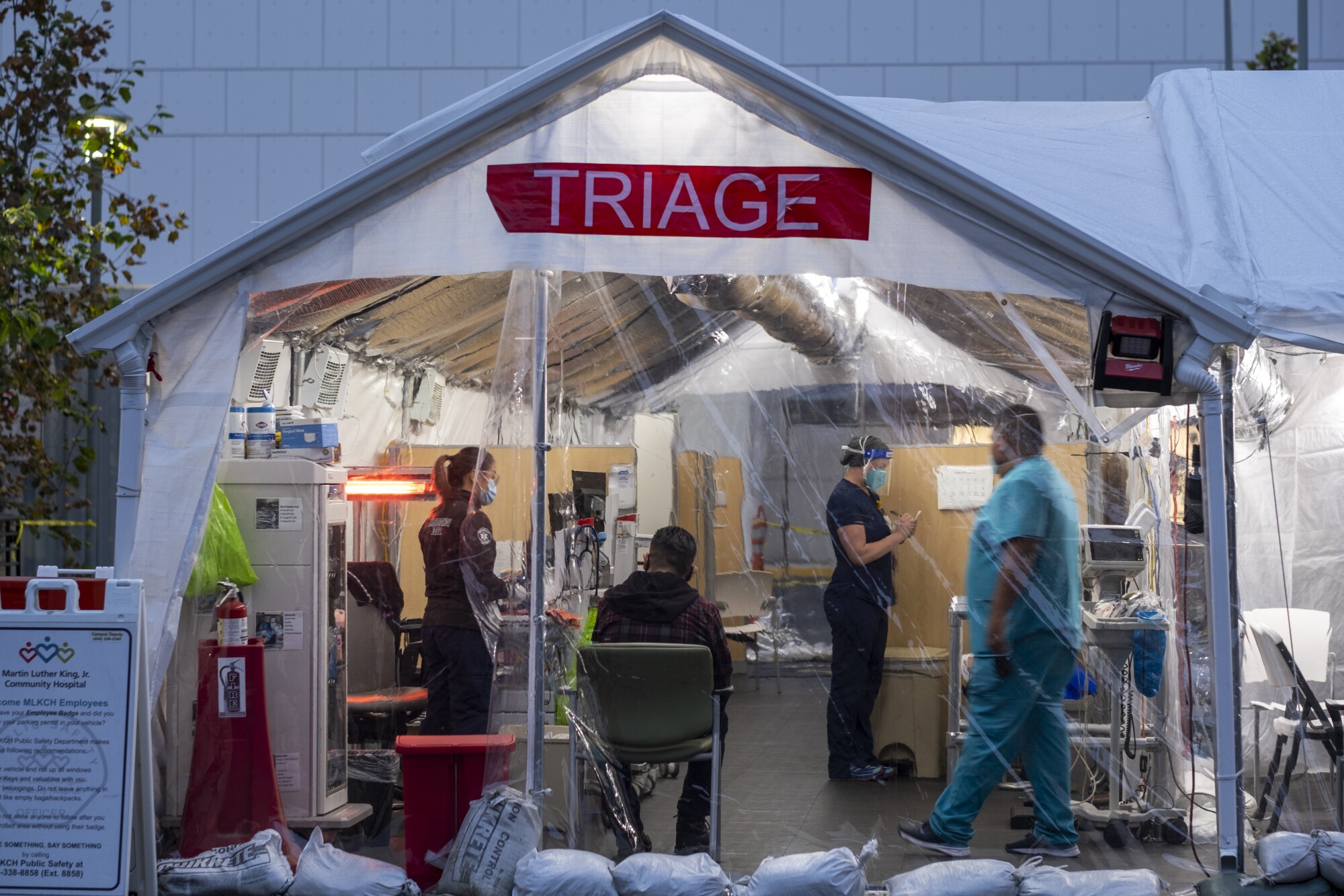 Healthcare workers and patients are seen inside a triage tent