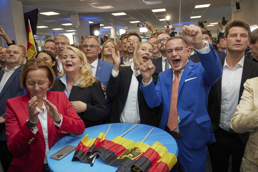 Alice Weidel, center, and Tino Chrupalla, center rught, both AfD federal chairmen, cheer at the AfD party headquarters during the forecast for the European elections, in Berlin, Sunday June 9, 2024. (Joerg Carstensen/dpa via AP)