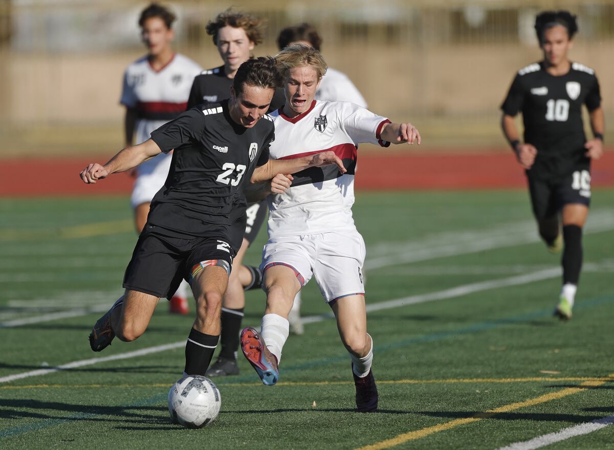 Marina's Enrique Guerrero (23) battles Laguna Beach's Jaxson Hutcheon on Friday.