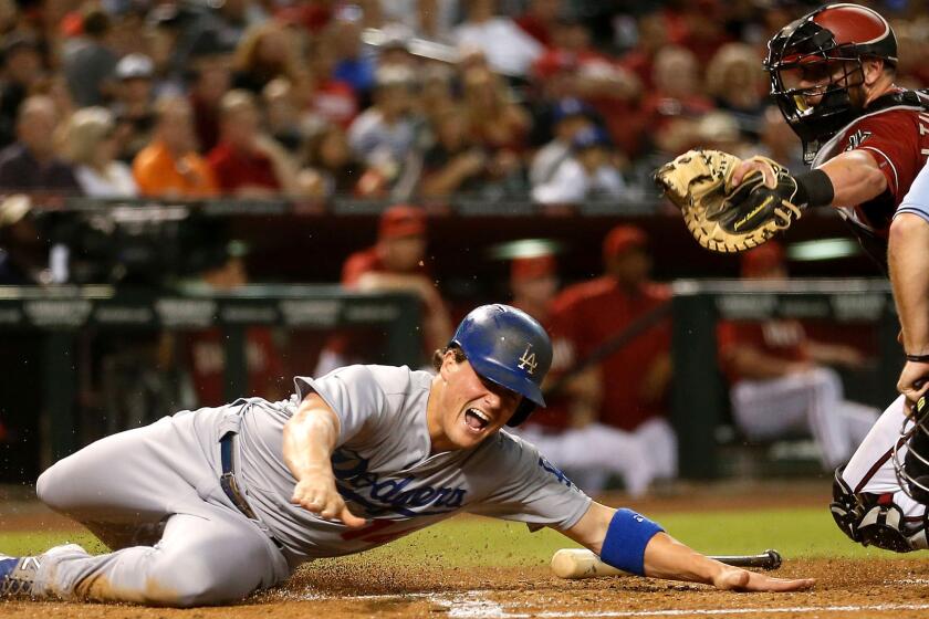 Dodgers outfielder Enrique Hernandez avoids the tag attempt of Diamondbacks catcher Jarrod Saltalamacchia to score a run in the third inning in Phoenix on July 1.