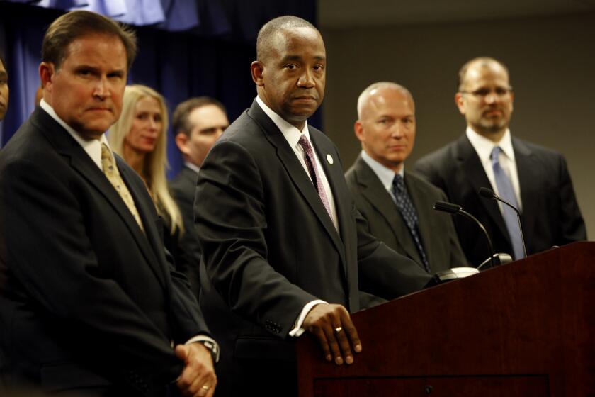 U.S. Atty. Andre Birotte Jr., center, speaks during a news conference Friday to announce political corruption charges filed in a case involving a massive healthcare fraud scheme.