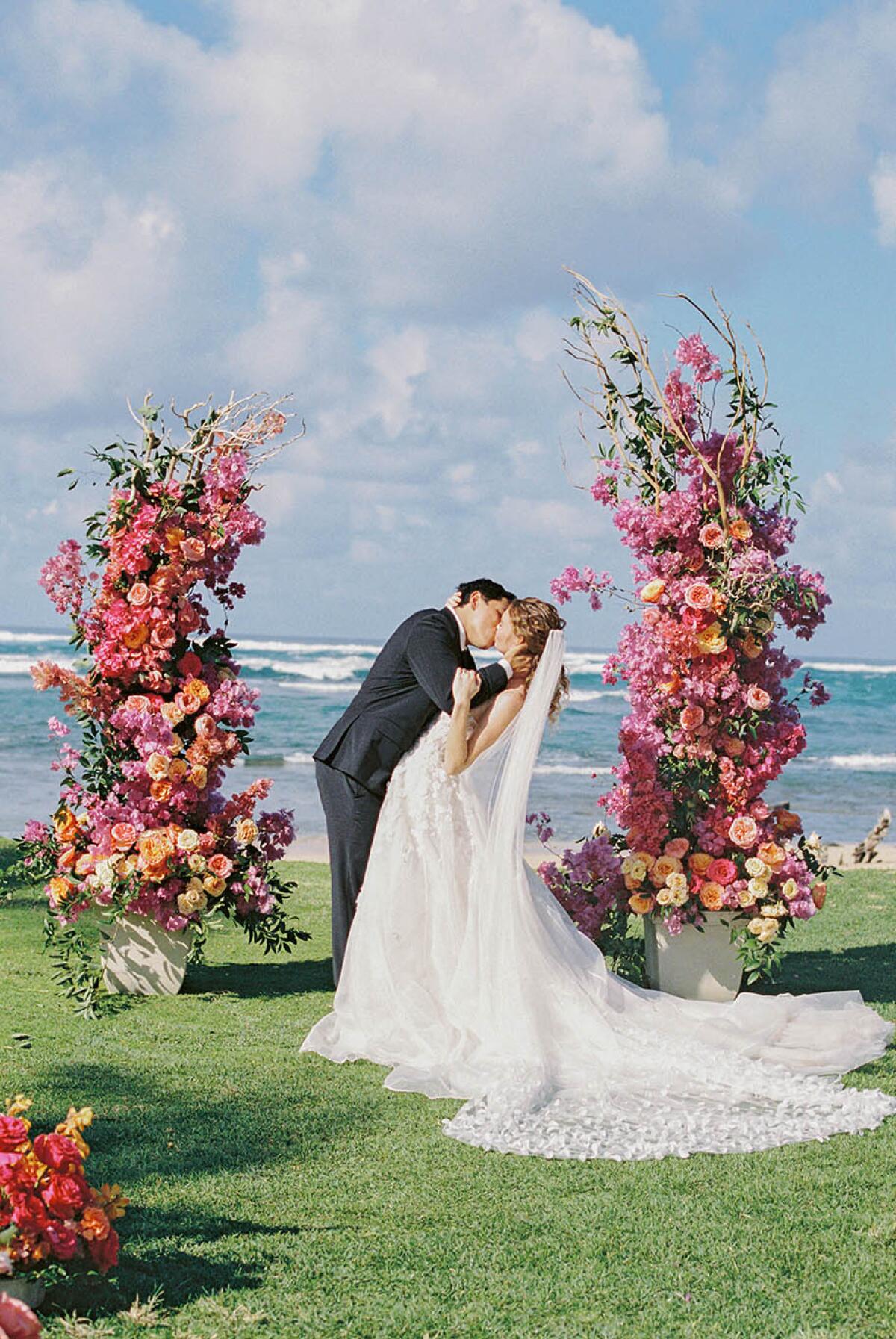 A couple kisses to tie the knot at Loulu Palms.