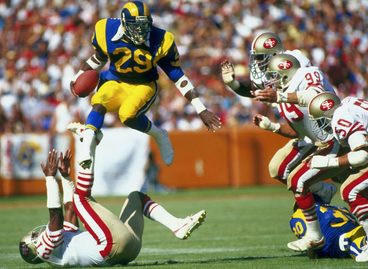 Los Angeles Rams Hall of Fame running back Eric Dickerson goes airborne to avoid the San Francisco 49ers defense.