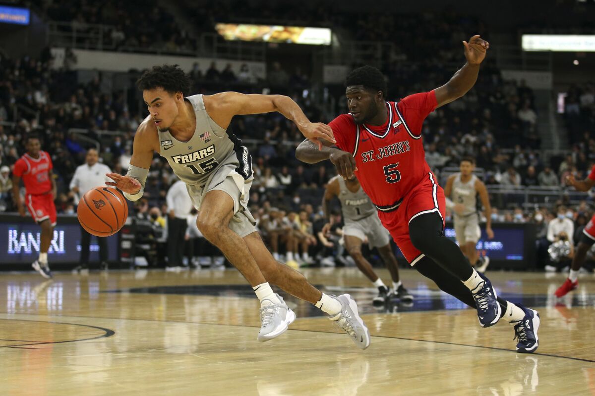 Providence's Justin Minaya (15) dribbles the ball after stealing it from St. John's Dylan Addae-Wusu (5) during the first half of an NCAA basketball game on Saturday, Jan. 8, 2022, in Providence, R.I. (AP Photo/Stew Milne)
