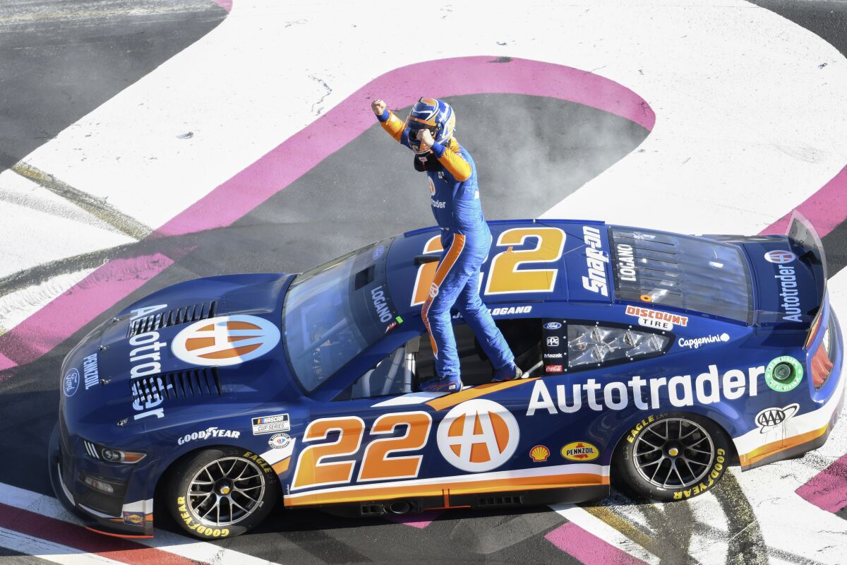 Joey Logano stands on his car after winning the NASCAR Cup Series auto race at Atlanta Motor Speedway on Sunday, March 19, 2023, in Hampton, Ga. (AP Photo/Hakim Wright Sr.)