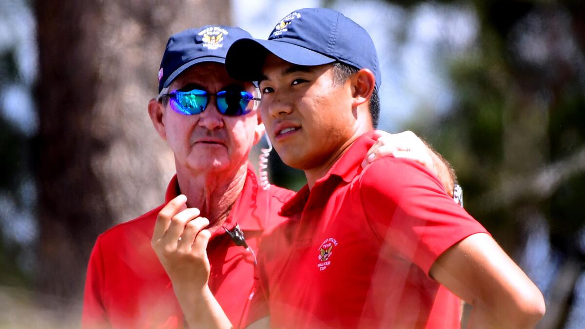 Collin Morikawa of the United Statesconfers with captain Spider Miller at the fourth tee box during his singles victory Saturday.