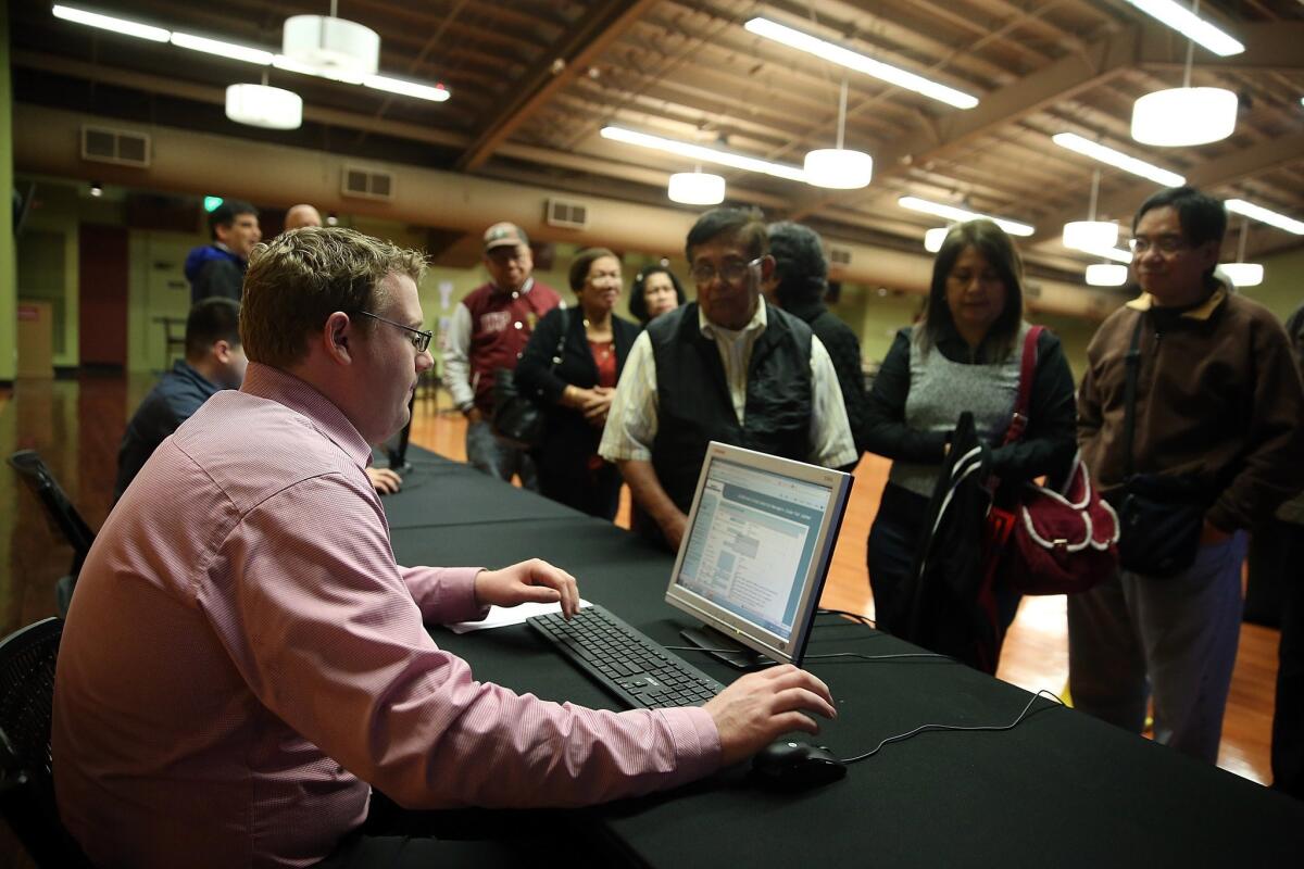 A worker registers job seekers during a job fair at California's Great America theme park in February in Santa Clara. Hundreds of job seekers lined up to apply for one of the 2,500 jobs available at the theme park.