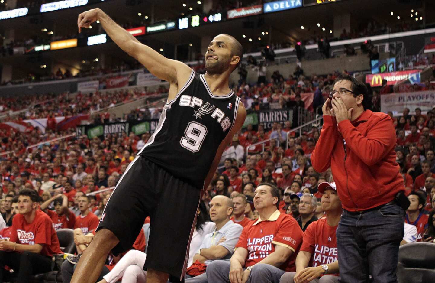 A fan tries to distract Spurs point guard Tony Parker, who watches his three-point shot go through the basket in the second half of Game 3 on Saturday afternoon.