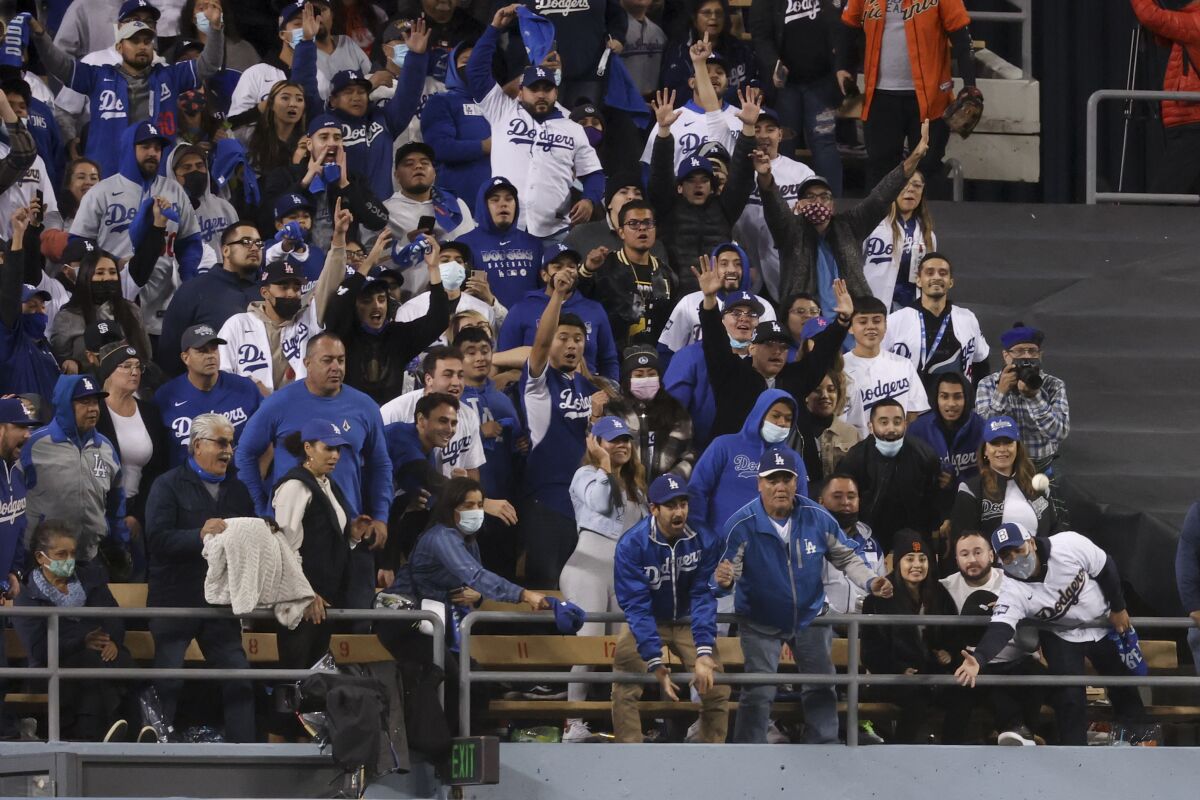 Fans in the pavilion reach for a two-run home run ball hit by Will Smith in the eighth inning of the Dodgers' 7-2 win.