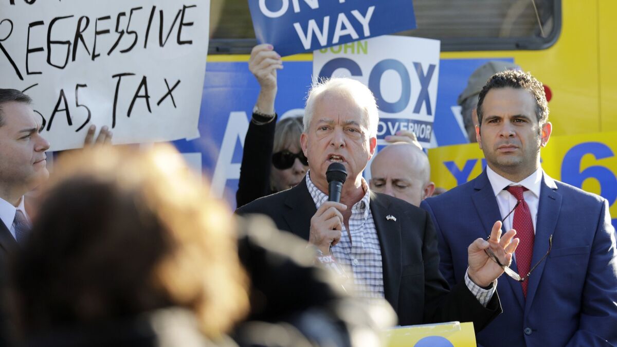 Republican gubernatorial candidate John Cox addresses Proposition 6 rally Oct. 18 in Burbank. He is flanked by Carl DeMaio, chairman of the Yes on 6 campaign, left, and Republican candidate for state controller Konstantinos Roditis.