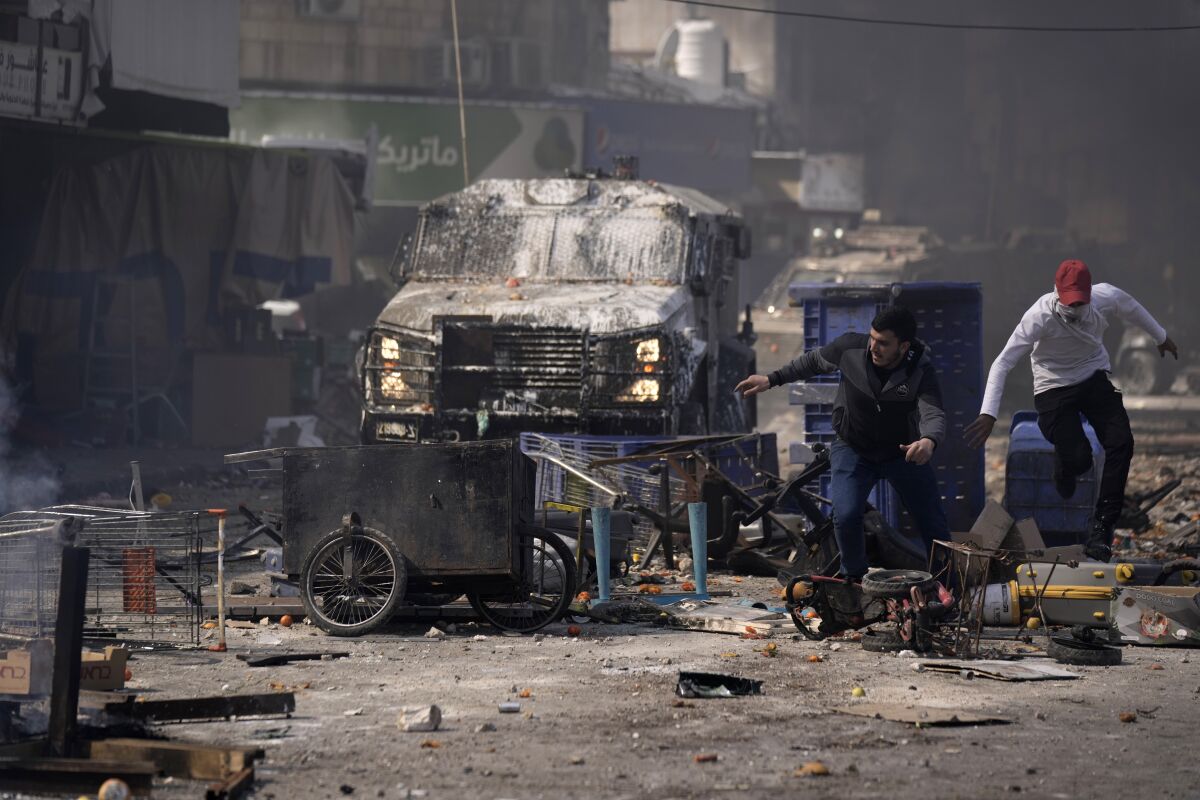 Vehicle and debris in street after clash between Palestinians and Israeli forces