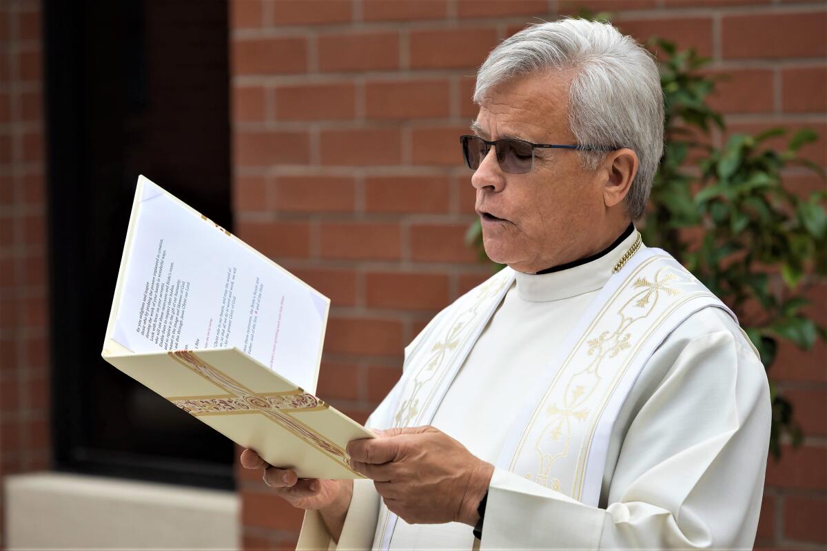 Fr. Mike Hanifin leads a prayer before blessing a new set of bathrooms at Costa Mesa's Saint Joachim Catholic Church Friday.