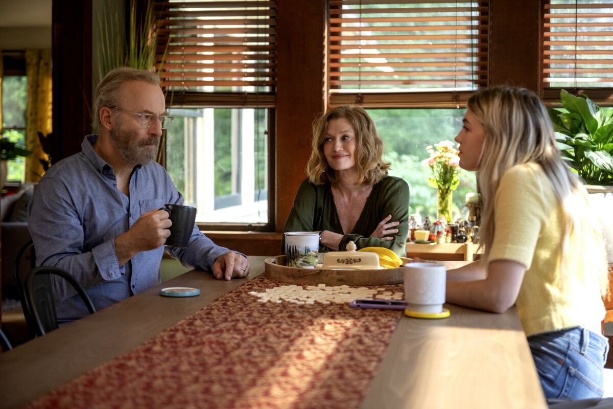 A man and woman and their adult daughter sit at a table drinking coffee in a scene from "Lucky Hank."