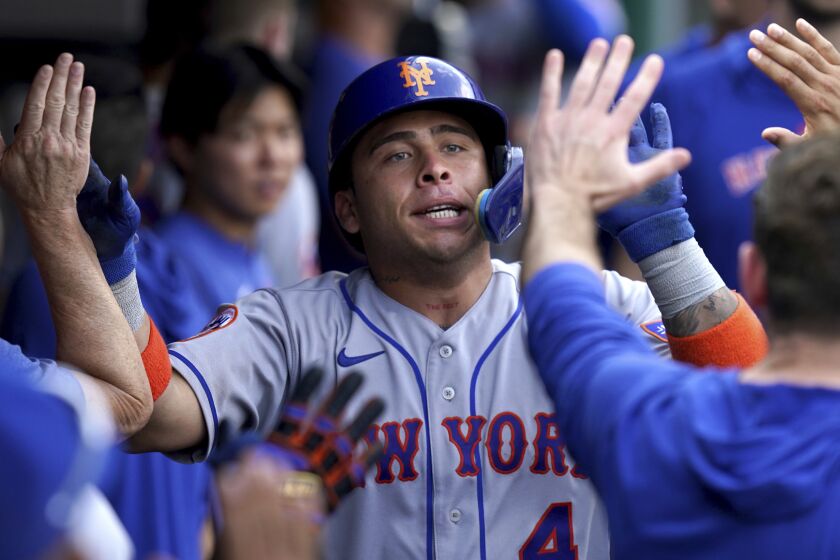 New York Mets' Francisco Alvarez is congratulated in the dugout after hitting a home run against the Pittsburgh Pirates in the eighth inning of a baseball game in Pittsburgh, Saturday, June 10, 2023. (AP Photo/Matt Freed)