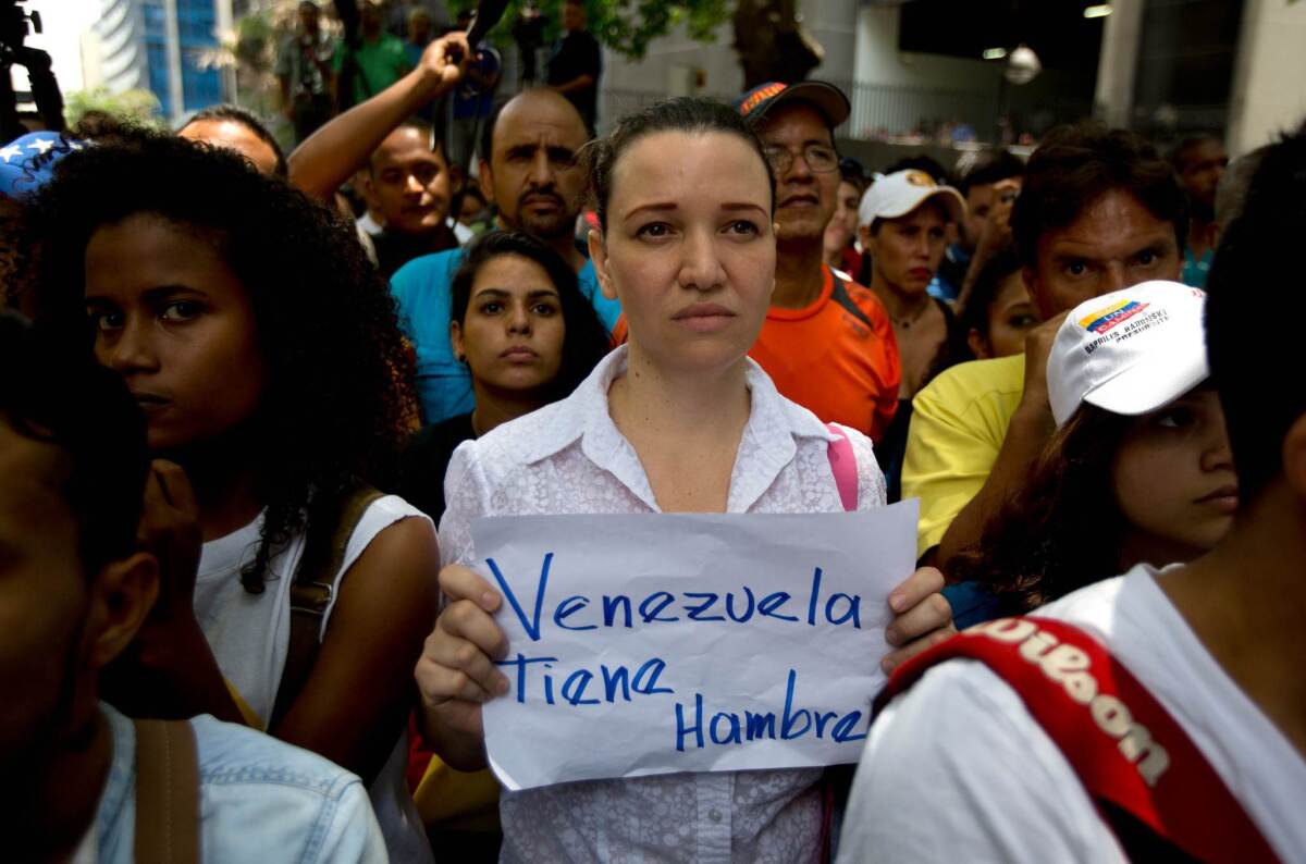 Una mujer sostiene un cartel que dice "Venezuela tiene hambre" durante una manifestación de la oposición en apoyo a una referendo revocatorio del mandato del presidente Nicolás Maduro, en Caracas, Venezuela, el miércoles 25 de mayo de 2016. (Foto AP / Ariana Cubillos). (AP Photo/Fernando Llano)