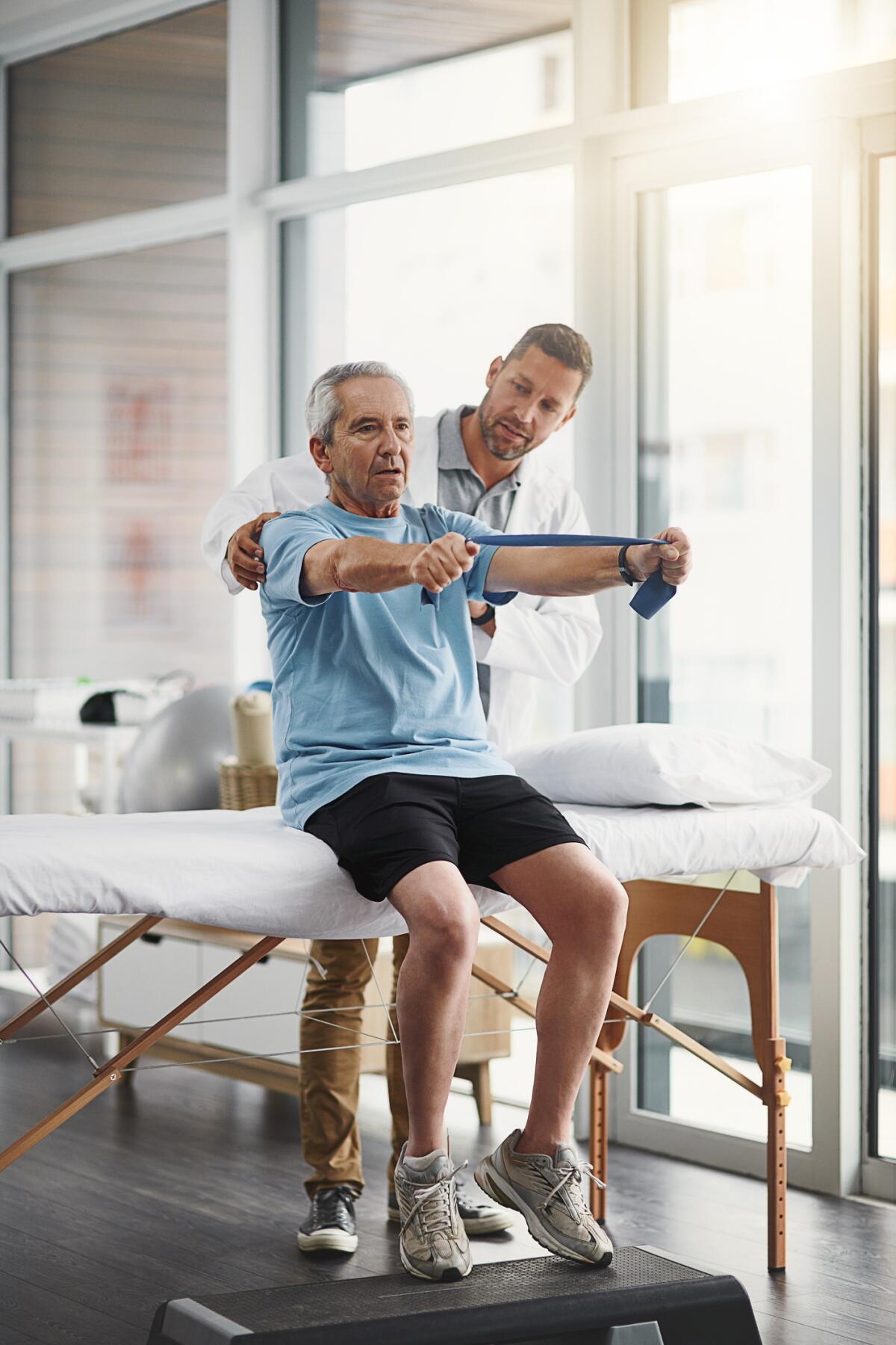 Shot of a young male physiotherapist assisting a senior patient in recovery.