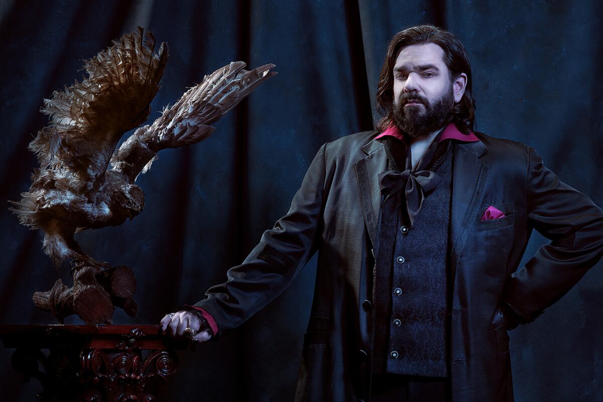 A man rests his hand on a lectern with a bird spreading its wings on it