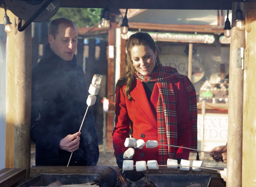 Britain's Prince William and Kate, Duchess of Cambridge toast marshmallows during a visit to meet students at the 'Christmas at the Castle' event held at Cardiff Castle, Wales, Tuesday Dec. 8, 2020, to hear how they have been supported with their mental health during lockdown, on the final day of a three-day tour across the country. (Jonathan Buckmaster/Pool via AP)