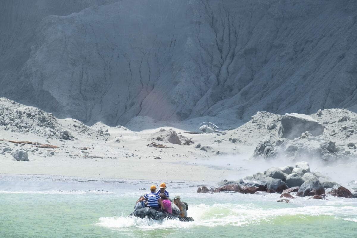 Tourists aboard a boat leave New Zealand's White Island volcano, which erupted.