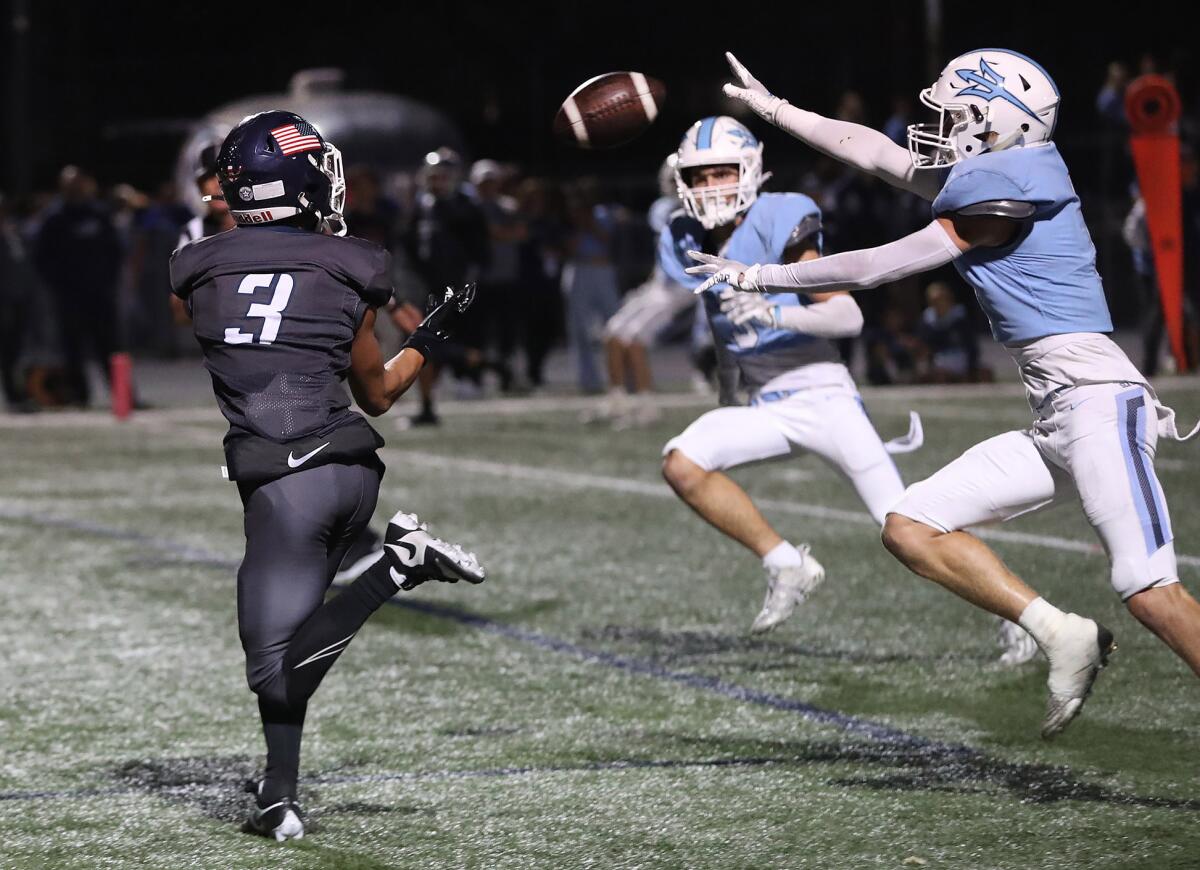 Newport Harbor's Cade Fegel (3) makes a catch in the end zone for a touchdown against Corona del Mar on Friday.