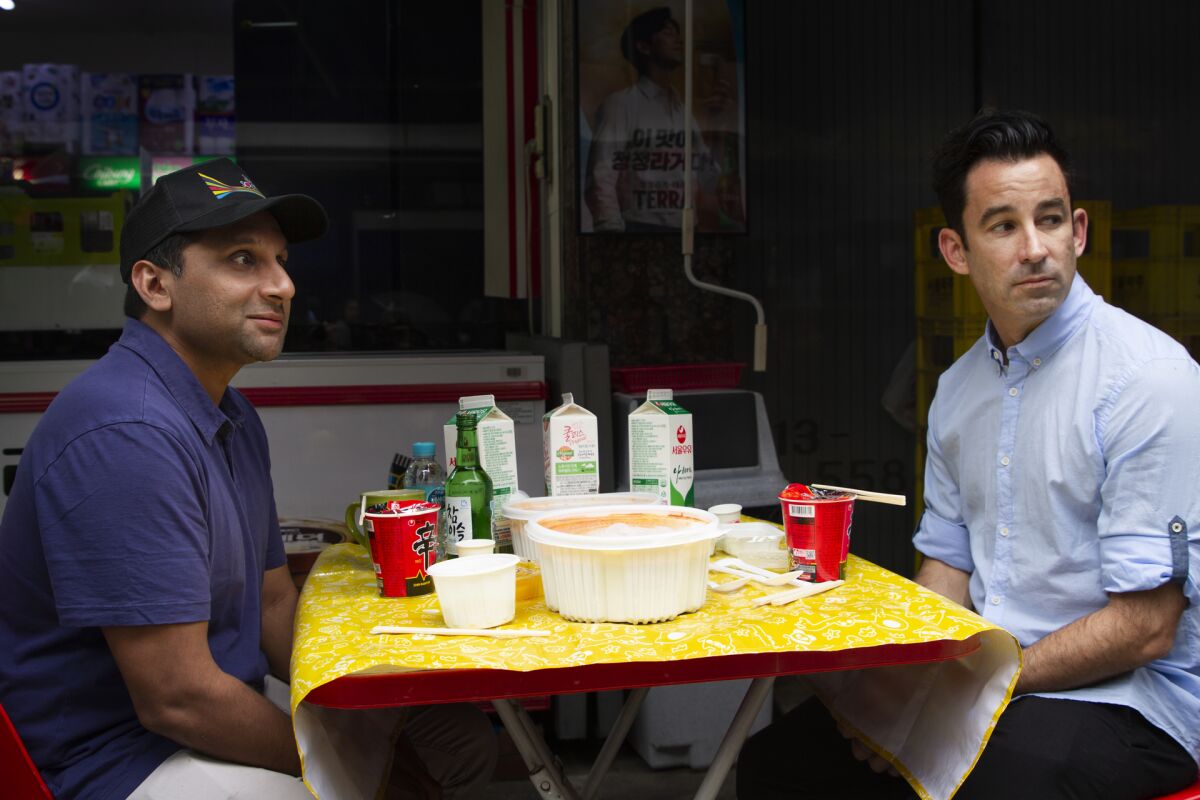 Ravi Patel, left, and Matt Pohlson try three tiers of spicy food as stress relief in South Korea.