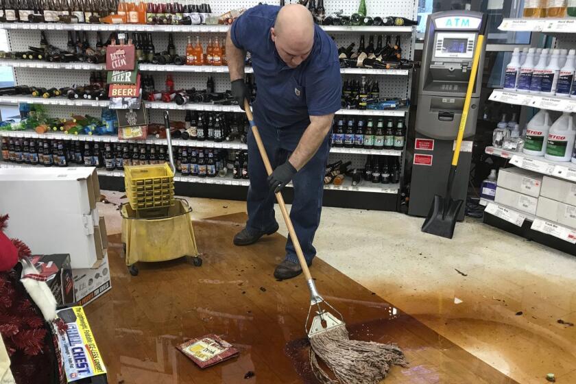 Randy Van Ness mops an aisle at Andy's Ace Hardware after a 7.0-magnitude earthquake hit in Anchorage, Alaska, Friday, Nov. 30, 2018. Scientists say the damaging Alaska earthquake and aftershocks occurred on a type of fault in which one side moves down and away from the other side. (Bill Roth/Anchorage Daily News via AP)