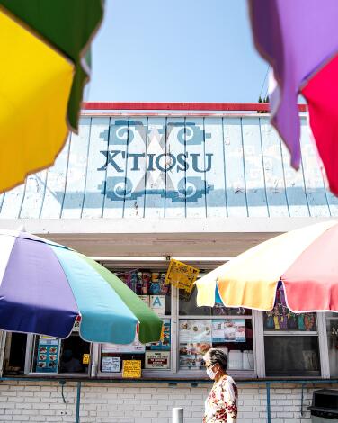 The facade of X'tiosu Kitchen, with colorful umbrellas in front