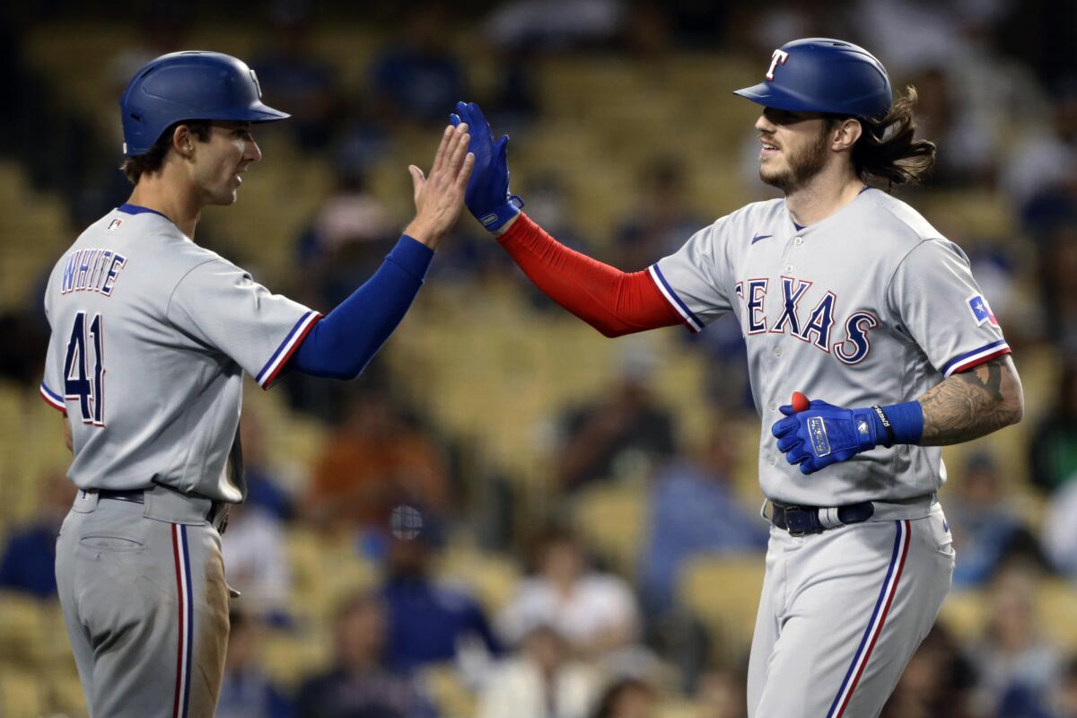 Rangers catcher Jonah Heim, right, celebrates with teammate Eli White after hitting a two-run home run.