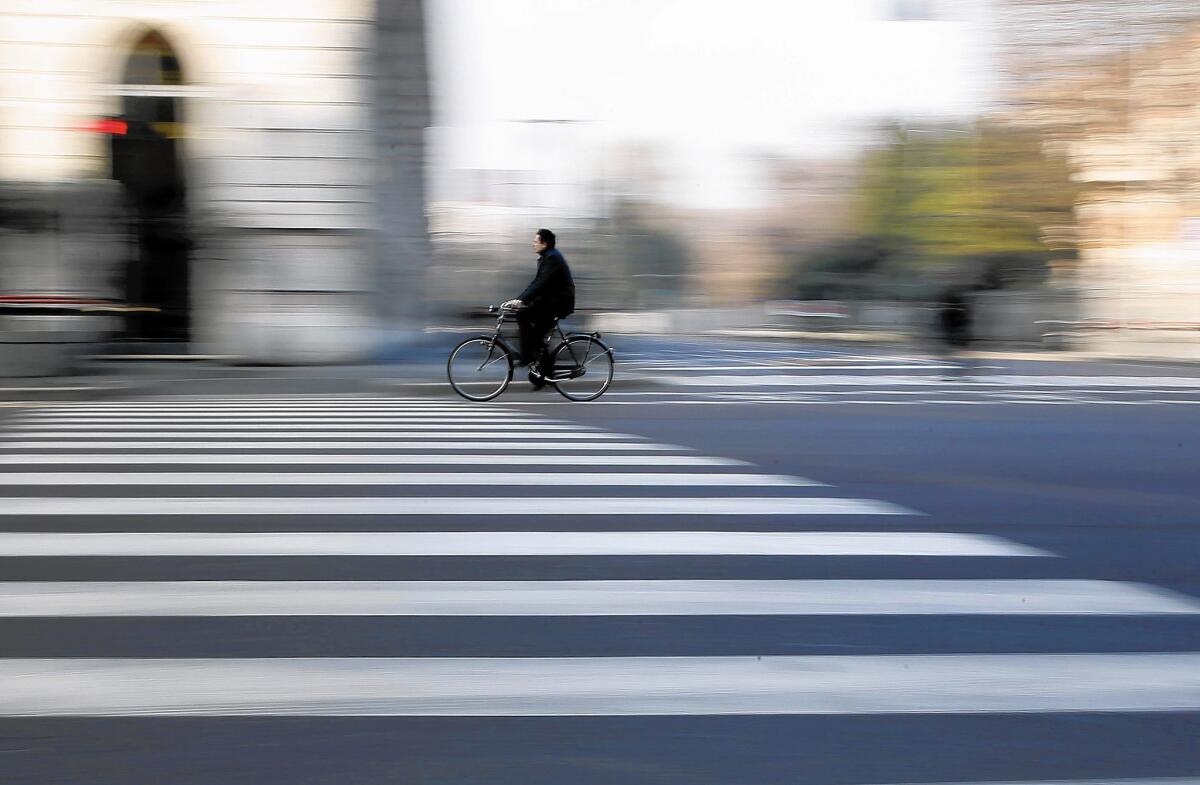 A cyclist pedals in Milan, Italy, which has ordered no-car times to combat pollution.