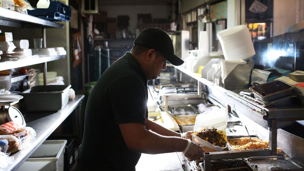 Sebastian Montero, 30, prepares a meal of super fries at Carnitas Michoacan, a 24-hour restaurant in Boyle Heights.