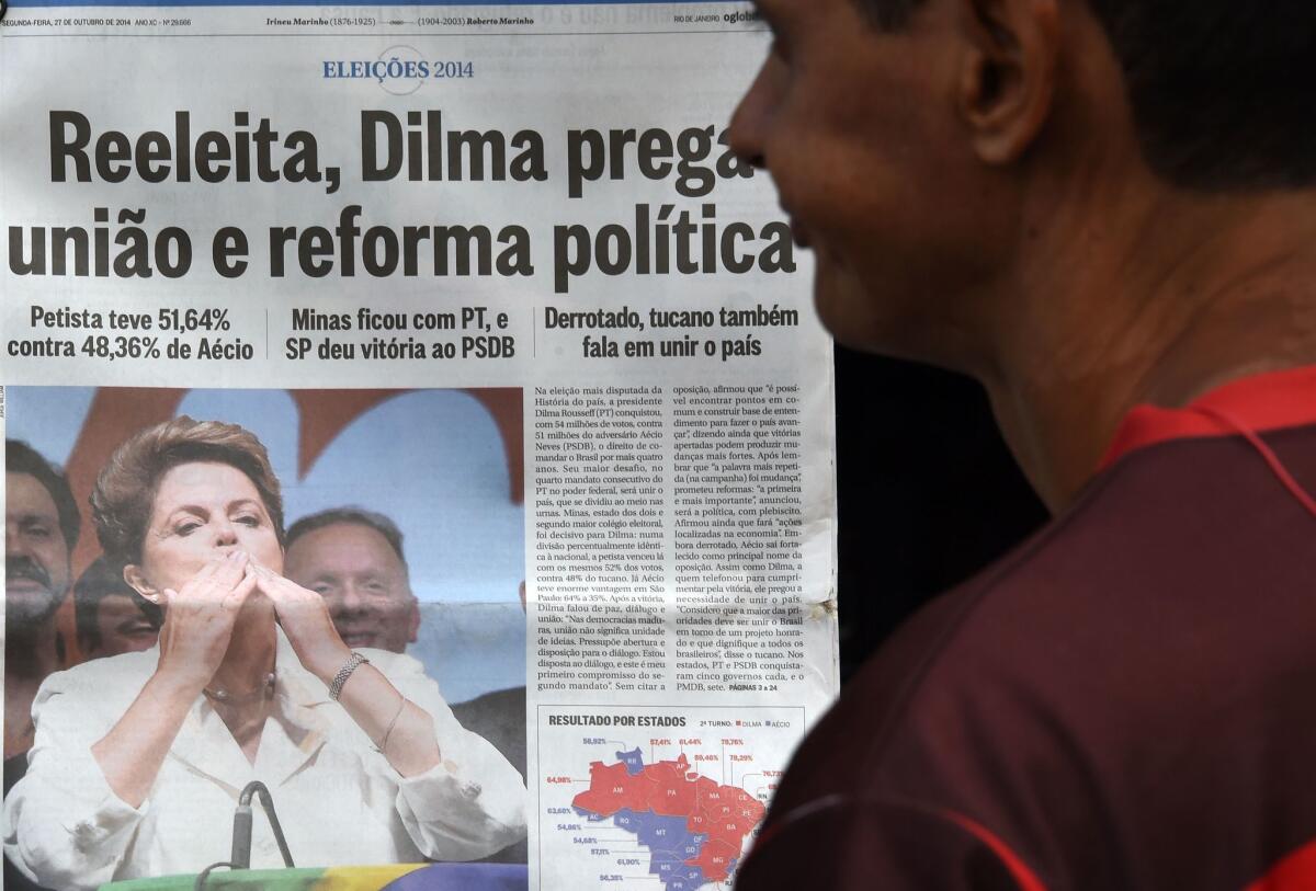 A man looks at Brazilian newspapers reporting on the reelection of President Dilma Rousseff.