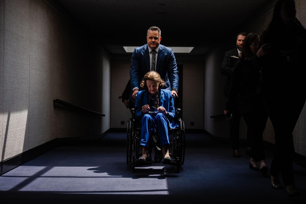 A man pushes a woman in a wheelchair 