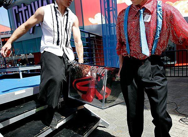 Job-seeking street performer Bonnie Morgan, center, is carried off stage in a see-through box after she auditioned for "StreetFest" at Universal CityWalk. StreetFest will feature performances at the theme park every Sunday, May 16 through June 13, from 3 to 8 p.m.