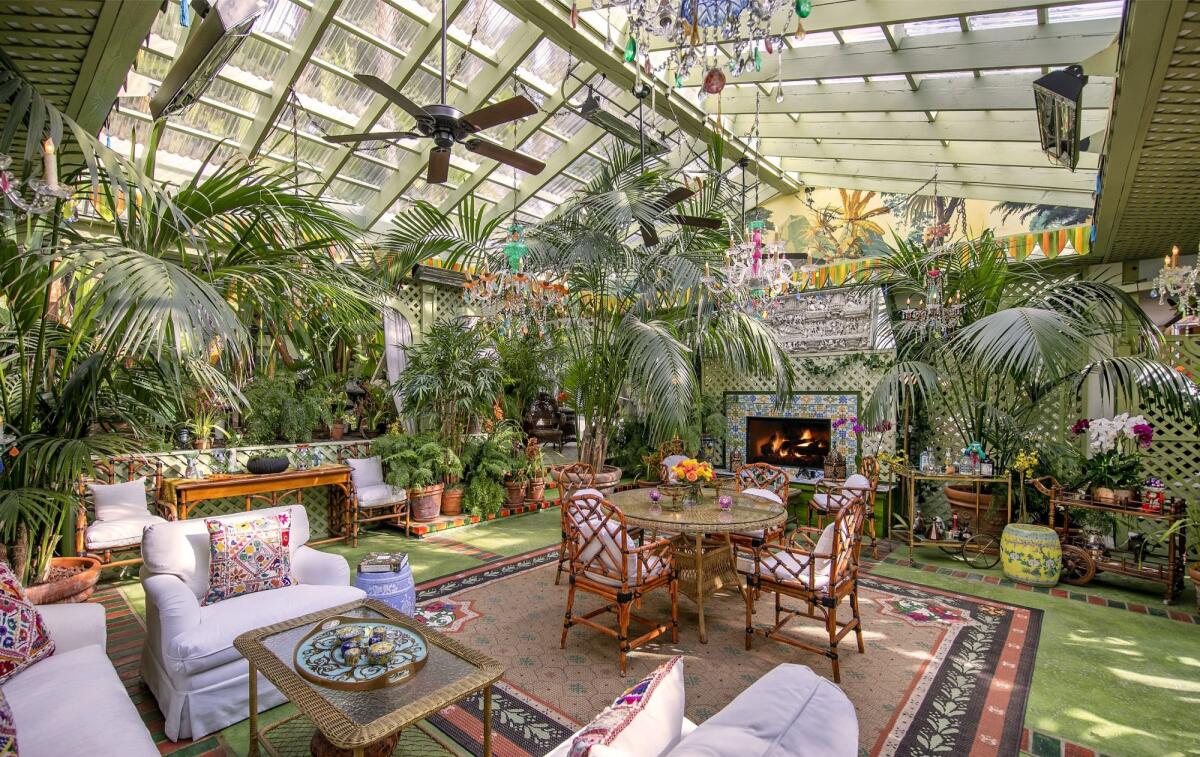 A solarium filled with plants and furniture.