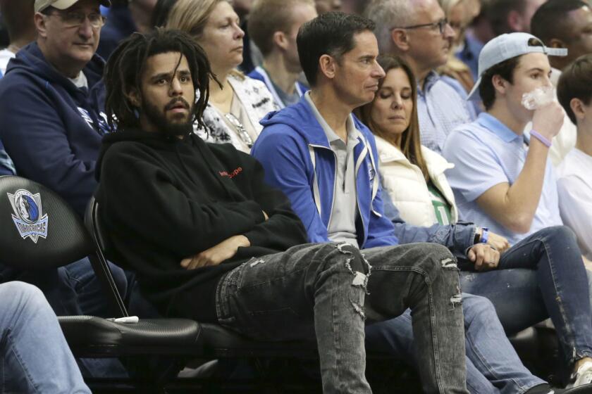 Recording artist J. Cole watches an NBA basketball game between the Detroit Pistons and Dallas Mavericks on Dec. 20, 2017. 