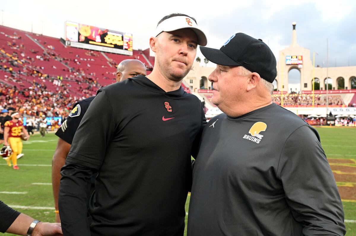 USC coach Lincoln Riley, left, and UCLA coach Chip Kelly greet each other before the rivalry game at the Coliseum last week.