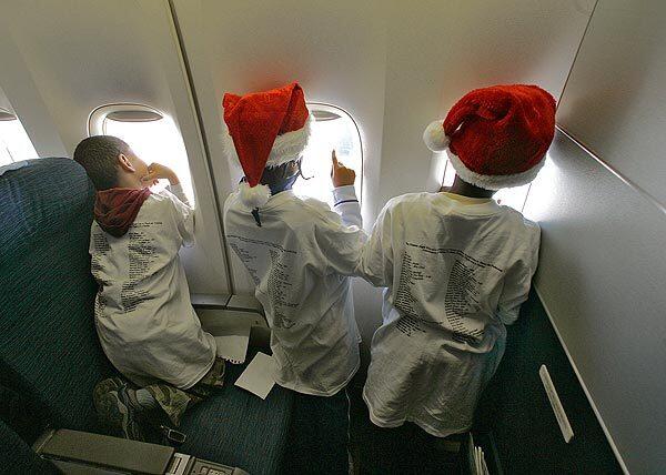 Children peer out the windows of a United Airlines jet on a 45-minute flight. The annual event, called the Fantasy Flight, is arranged by airline employees and funded through candy, book and bake sales.