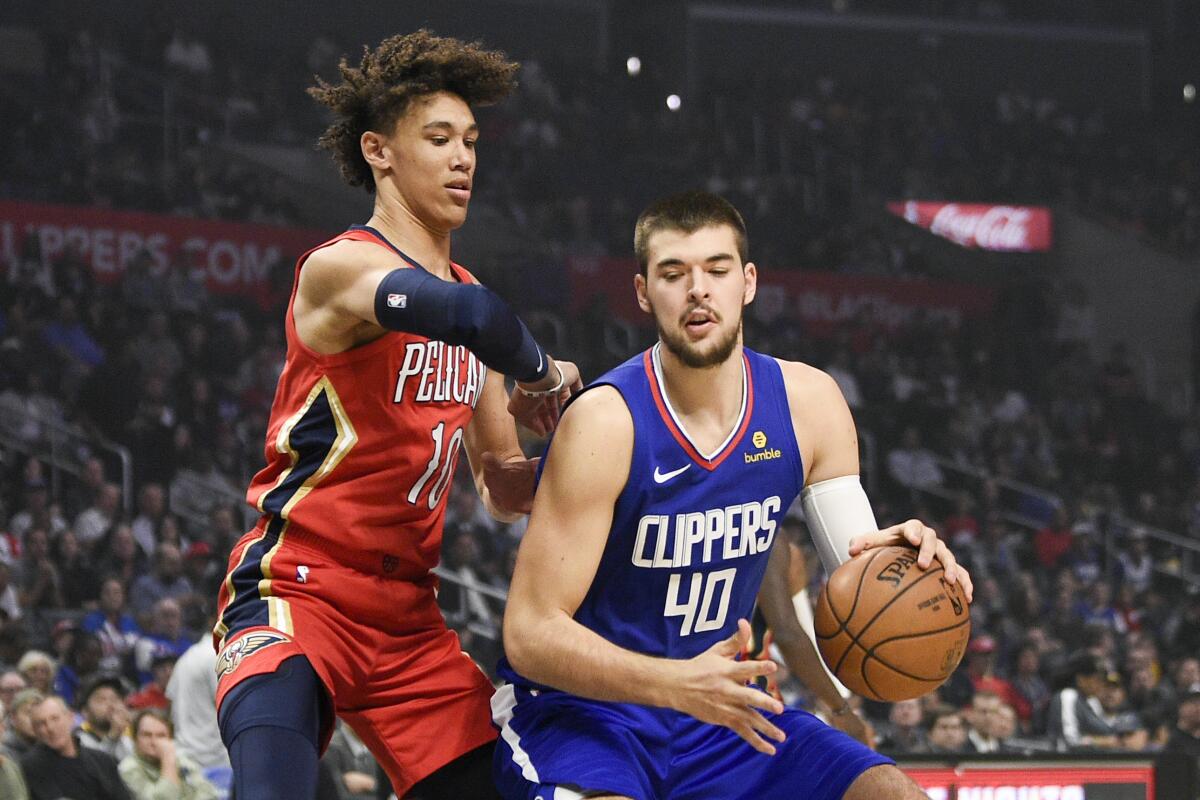 Clippers center Ivica Zubac, right, handles the ball while New Orleans Pelicans center Jaxson Hayes defends during the first half at Staples Center on Nov. 24, 2019.