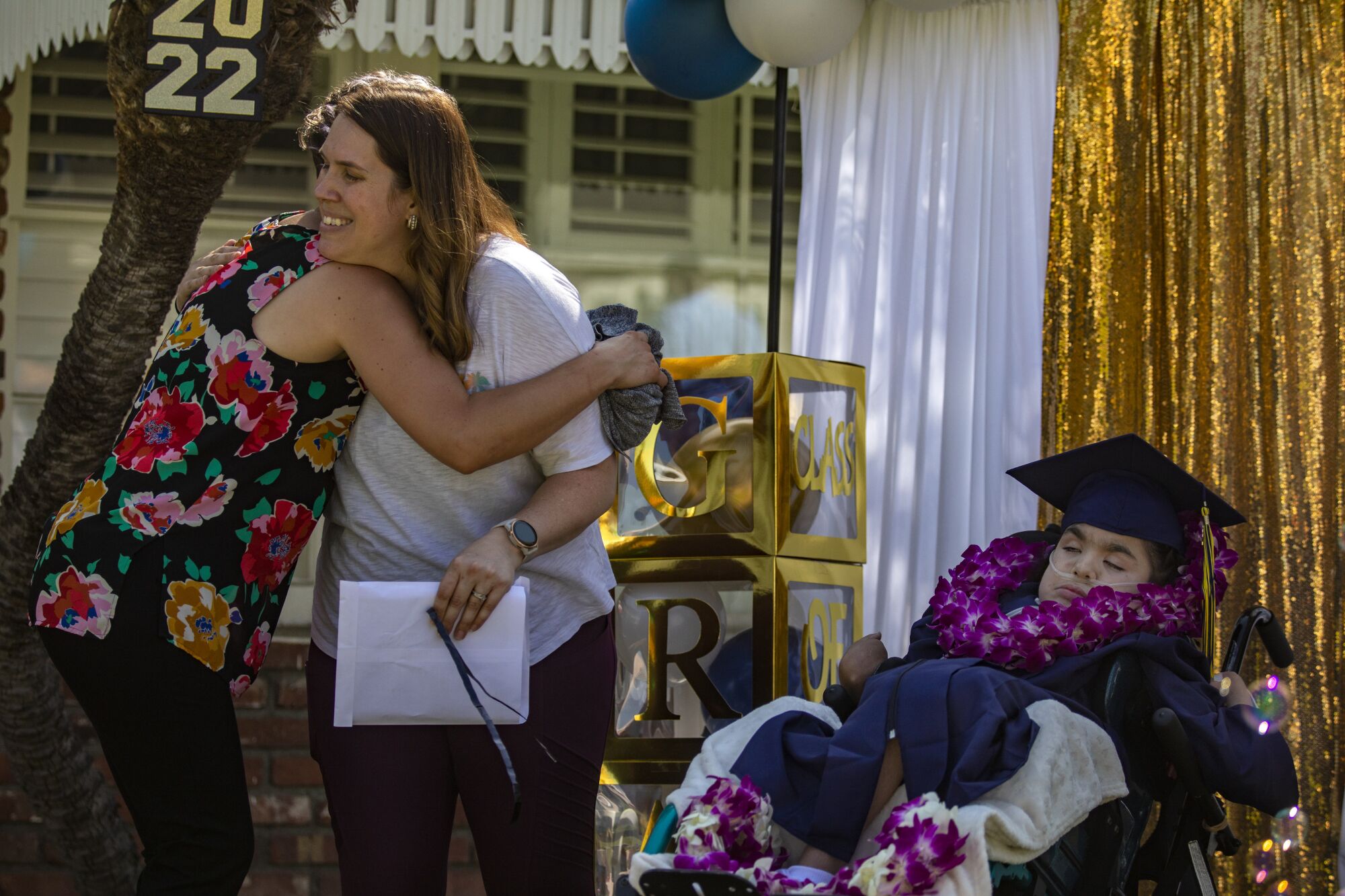 Providence TrinityKids Care chaplain Misty Wise hugs Penny Lopez, center, as she stands next to her daughter Hannah.