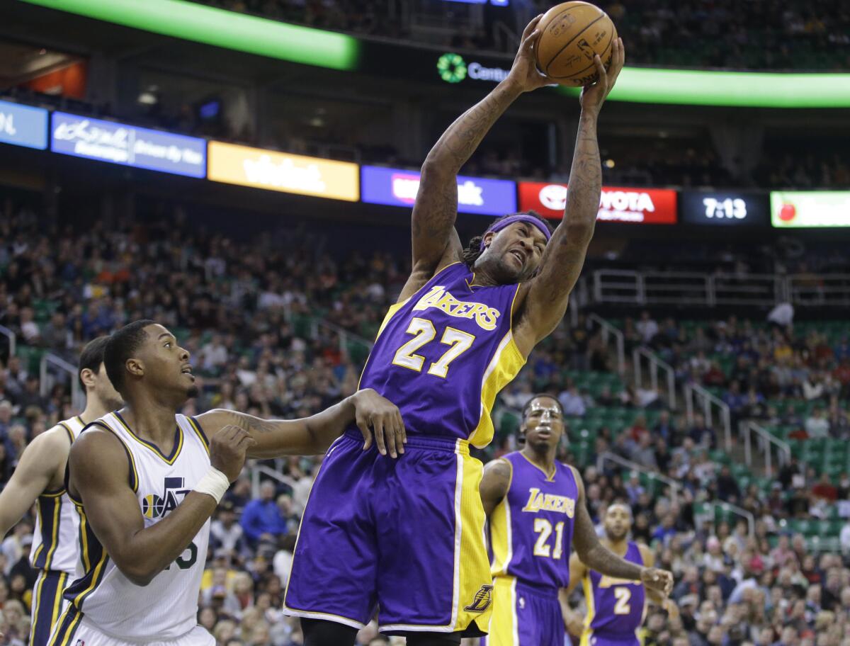 Lakers center Jordan Hill grabs a rebound over Jazz forward Derrick Favors.